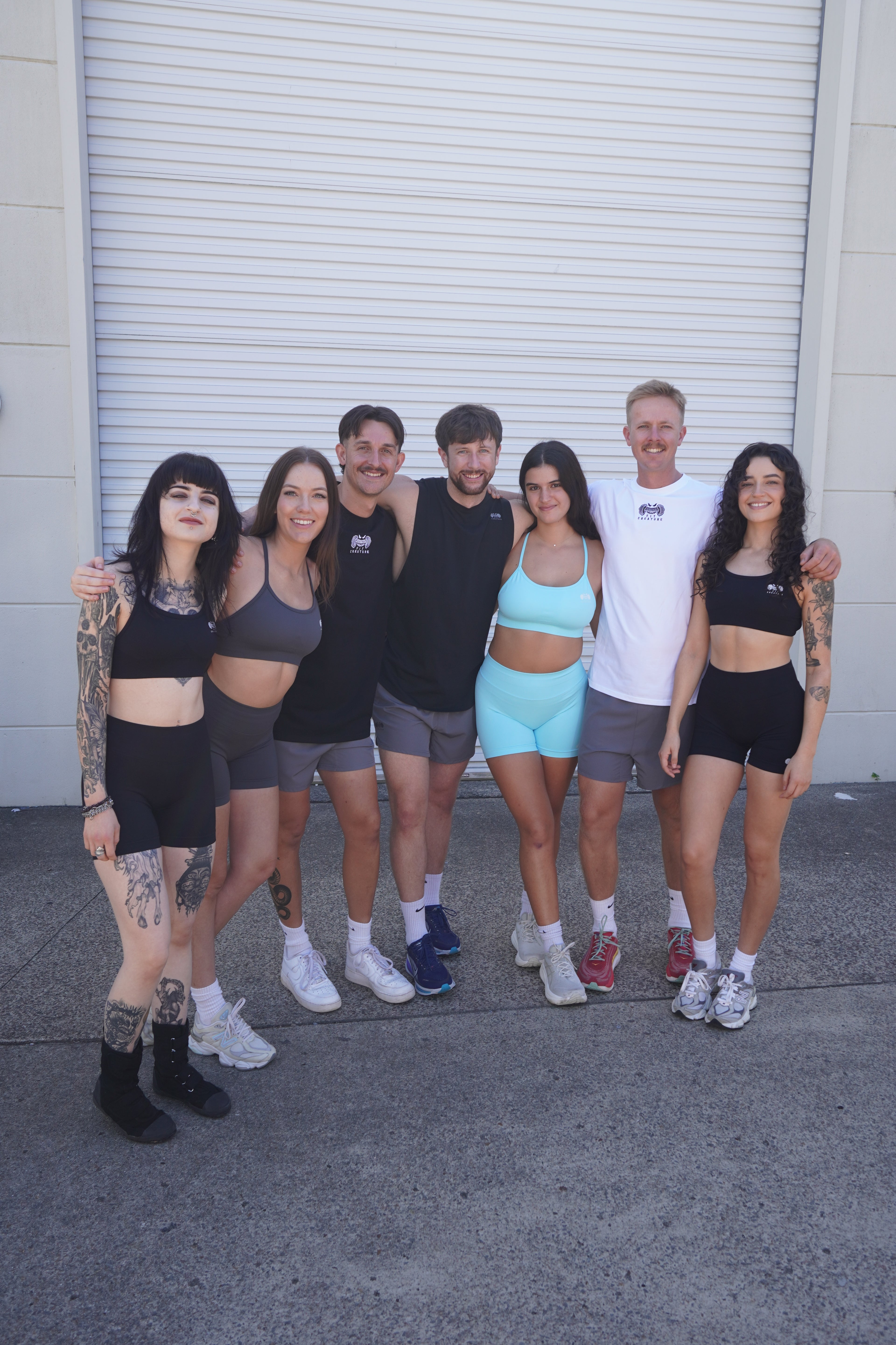 Group of people posing together outdoors on a street.