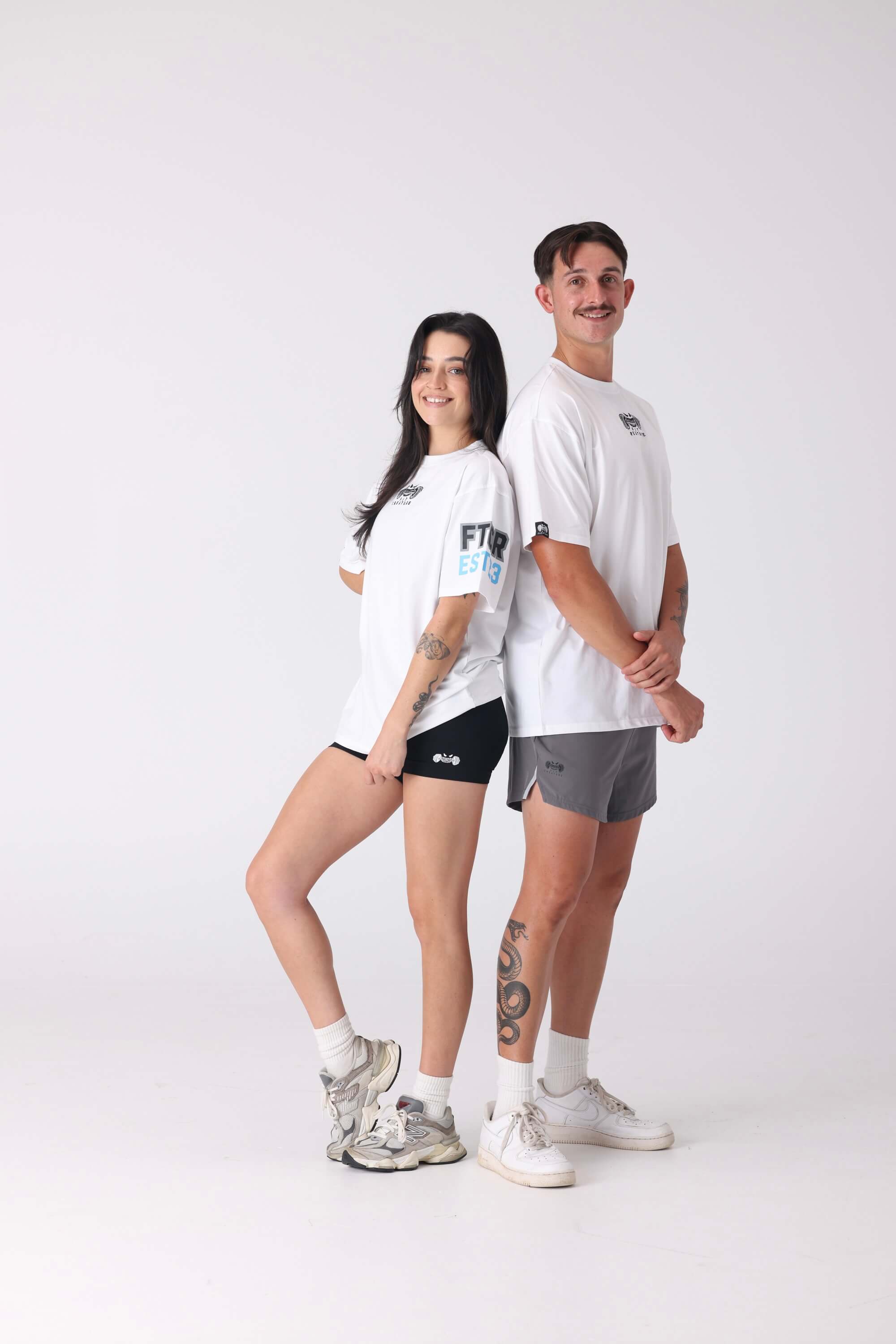 Two people wearing white t-shirts and shorts on a white background