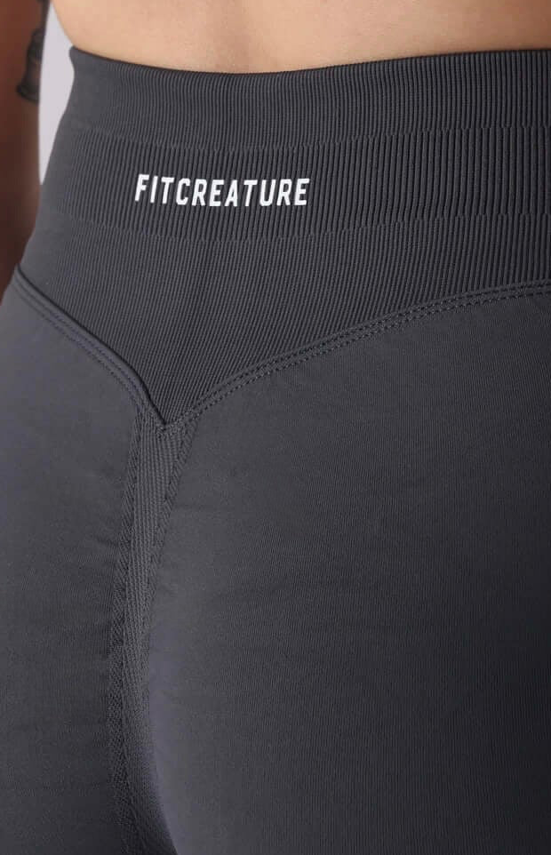 Person wearing grey athletic shorts with 'FYTCH' branding on a plain background